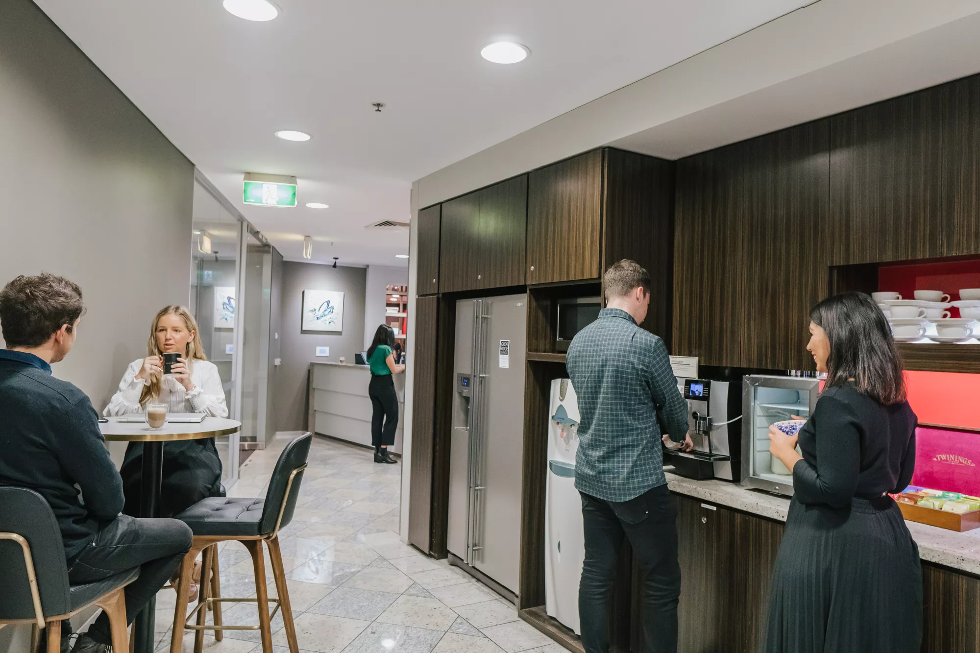 Clients in a modern coworking space enjoying fully stocked kitchen in Servcorp Southbank, Melbourne