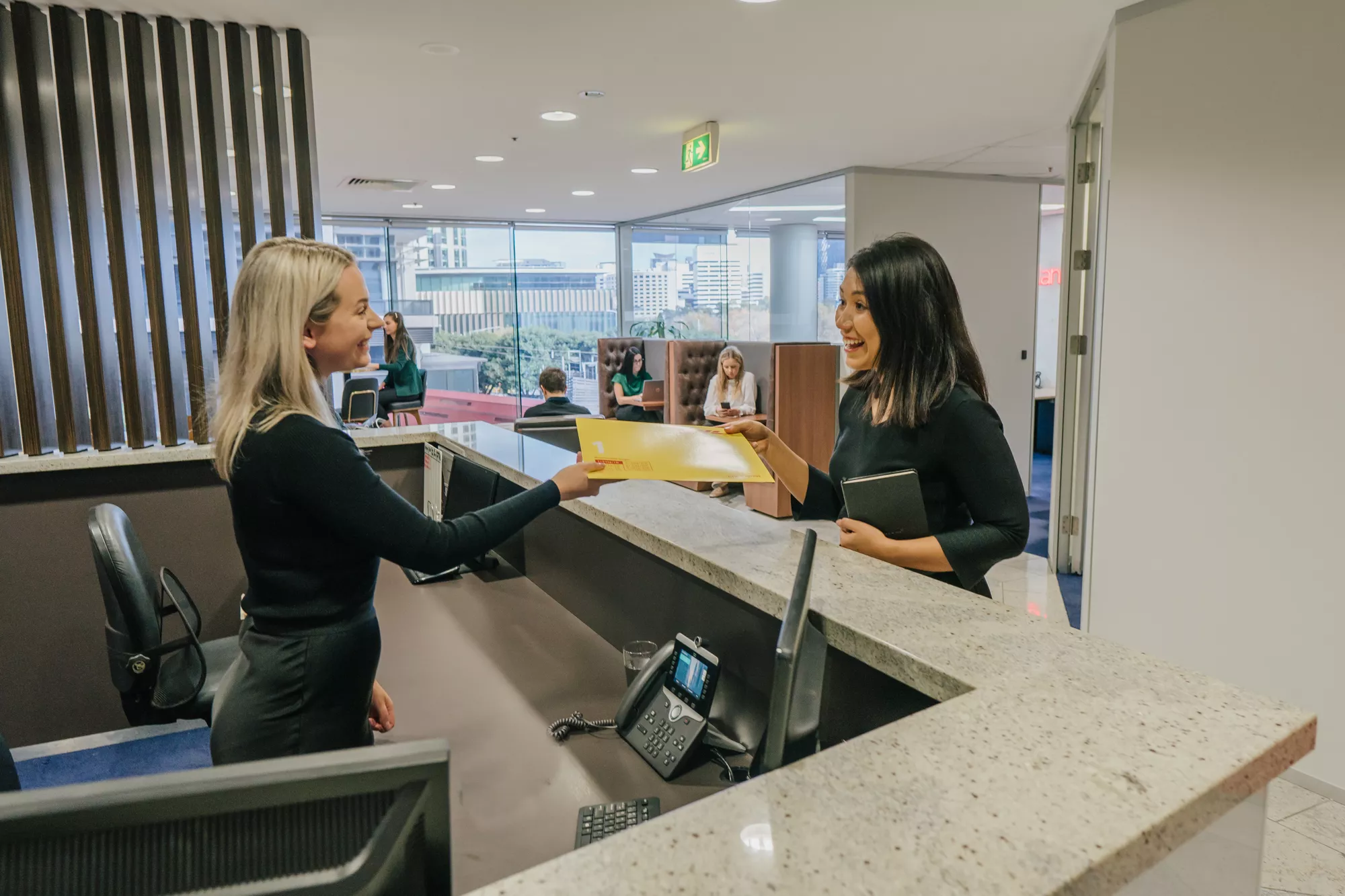 A client receiving a parcel from a dedicated receptionist in Servcorp Southbank Melbourne