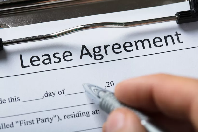 Using a pen to sign a lease agreement document