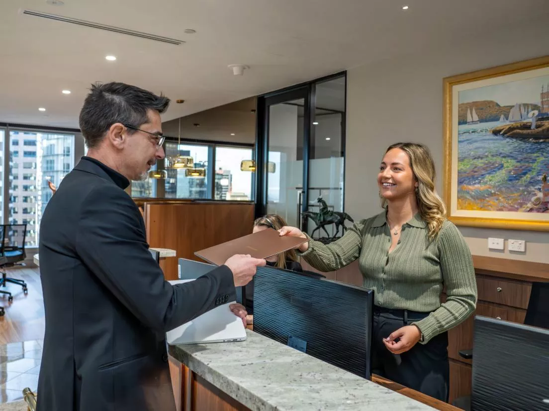 Client receiving files from a receptionist in Servcorp Chifley Tower