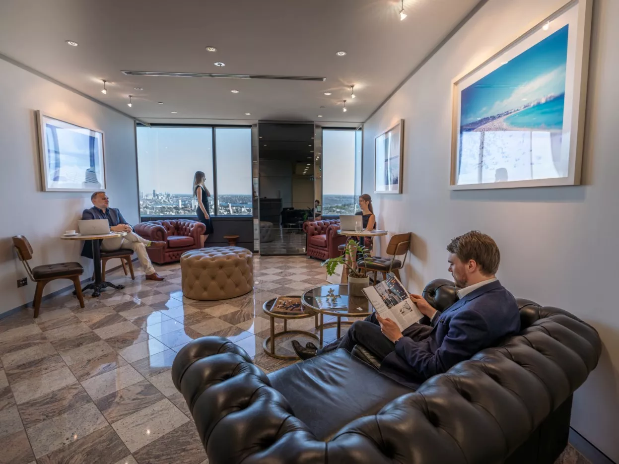 Clients working in a modern coworking space and enjoying the lounge with a view in Servcorp Westfield Tower 2