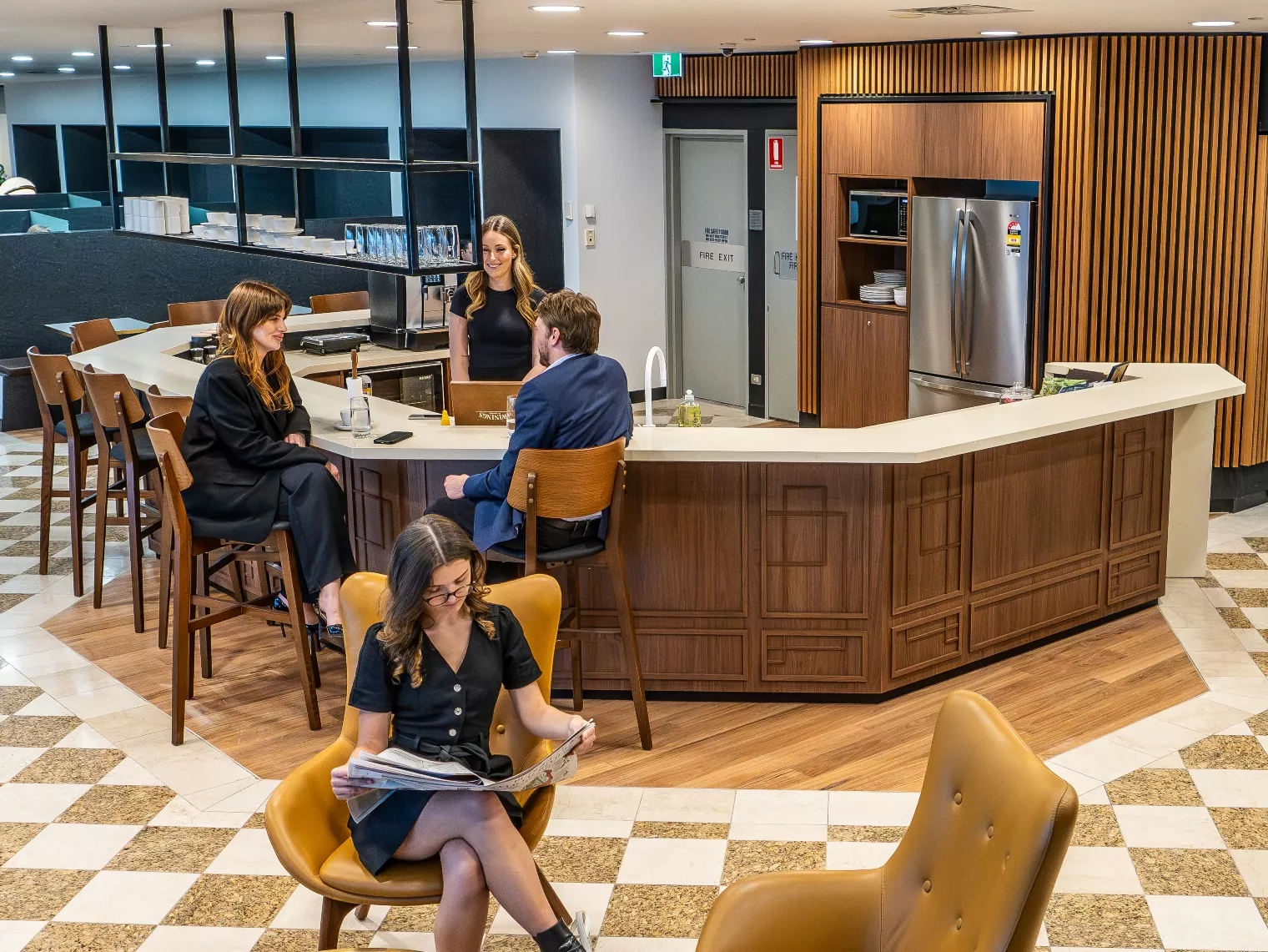 People enjoying their time in a modern coworking space lounge and fully stocked kitchen break room in Servcorp 25 Martin Place