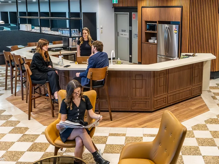 People enjoying their time in a modern coworking space lounge and fully stocked kitchen break room in Servcorp 25 Martin Place