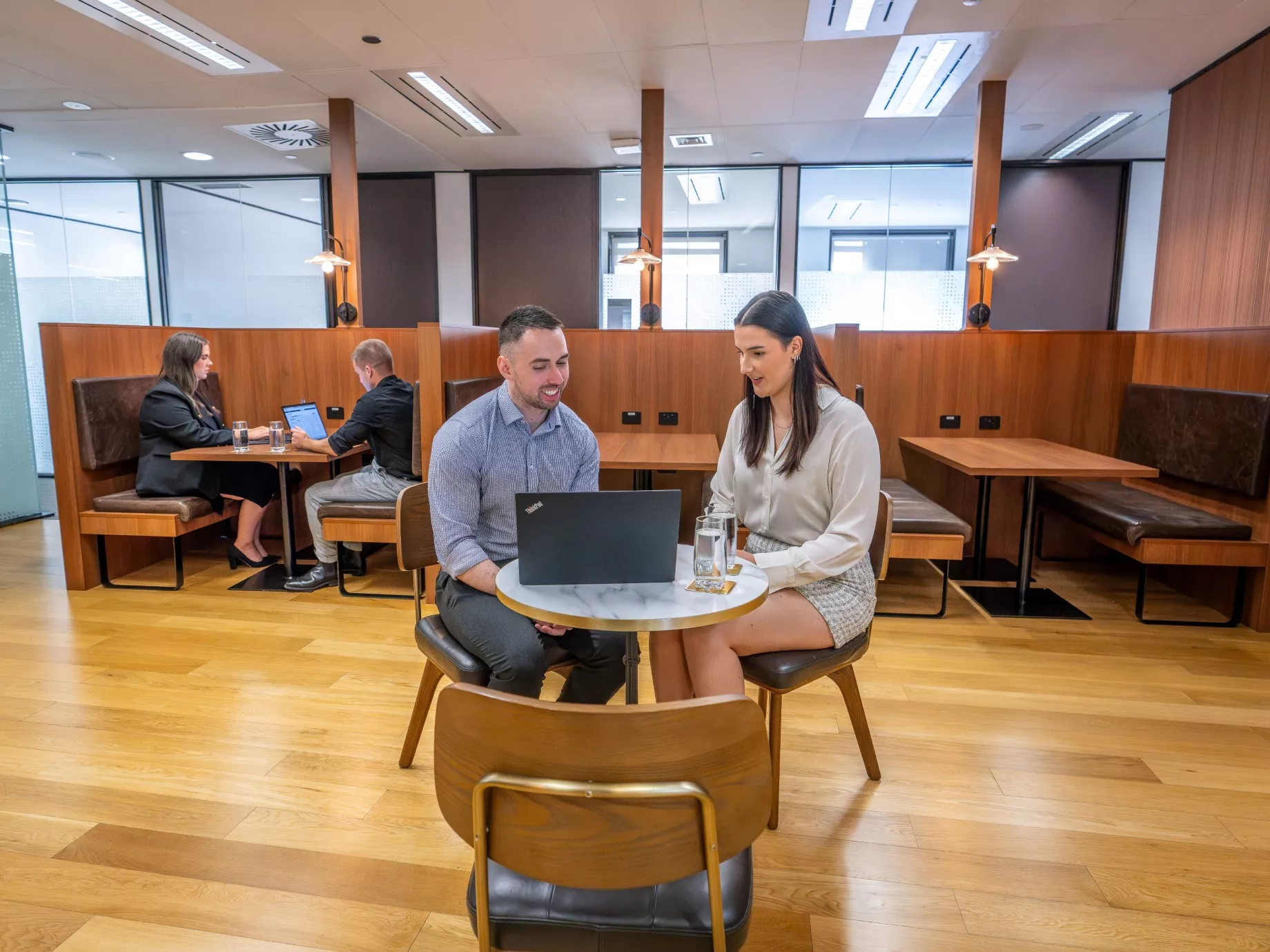 Close up on clients working on a hot desk in a coworking space with booths in Servcorp Reserve Bank Building, Hobart